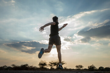 Silhouette of a man running against a colorful sky. Silhouette of a man running against a sunset background.