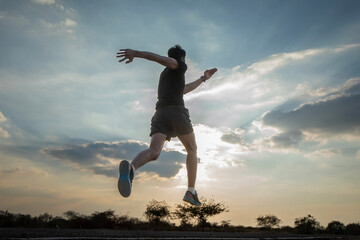 Silhouette of a man running against a colorful sky. Silhouette of a man running against a sunset background.