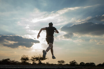 Silhouette of a man running against a colorful sky. Silhouette of a man running against a sunset background.