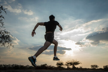 Silhouette of a man running against a colorful sky. Silhouette of a man running against a sunset background.