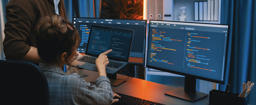 Serious of IT developers discussing intelligent website development coder system running data online two screens with laptop showing information network at neon light room at modern office. Infobahn.
