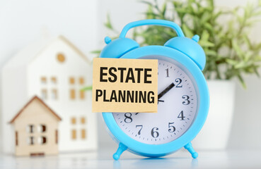 A blue alarm clock with a white paper that says Estate Planning on it