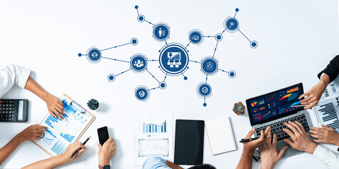 A dynamic team engaged in data management and strategy sessions, utilizing laptops and charts,...