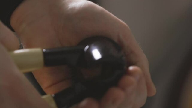 A skilled hand delicately cracks a walnut nut using nutcracker in a warm kitchen