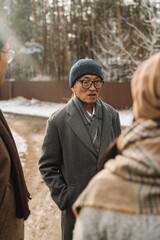 Grandfather standing and talking to grandmother and son standing next to him, on the street