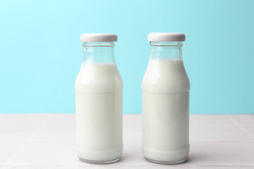 Fresh milk on white table against light blue background