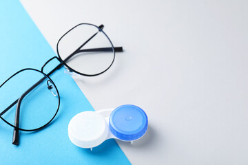Case with contact lenses and glasses on color background, closeup. Space for text