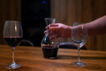 Red Wine Pouring into Empty Glass on Wooden Table
