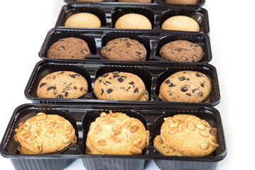 Various round cookies in an open box. Cookies in a pack on white