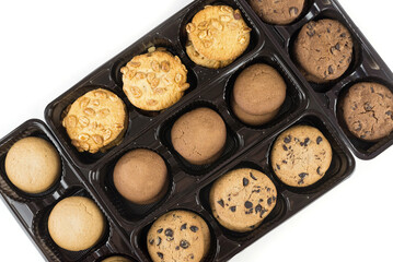Various round cookies in an open box. Cookies in a pack on white
