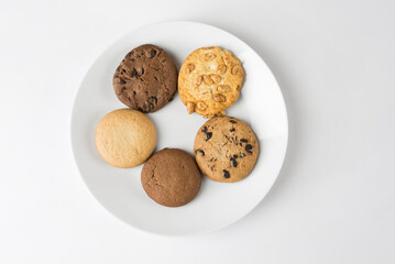 Different round cookies in a white plate on a white background