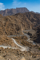 Oman, 03-06-2025: canyon and view of the winding road to Jebel Al Harim (Jabal Al Harim), the...