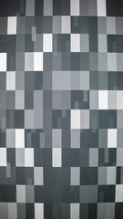 Abstract glitch-inspired pattern featuring a grid of pixelated rectangles in grayscale tones. The design resembles a digital error or data corruption effect.