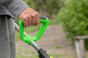 Electric grass trimmer.Professional gardening tool on lawn grass.Lawn care in backyard.