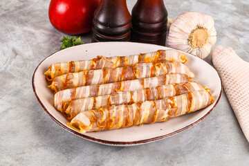 Raw sausages wrapped in bacon