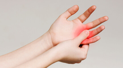 Pain and numbness in fingertips and palms. Woman massaging her sore hand, panorama