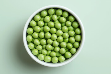 Fresh green peas in a white bowl on a light green background ready for cooking or snacking