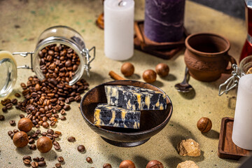 Marble cheese with coffee beans, macadamia nuts, candles, and brown sugar on table