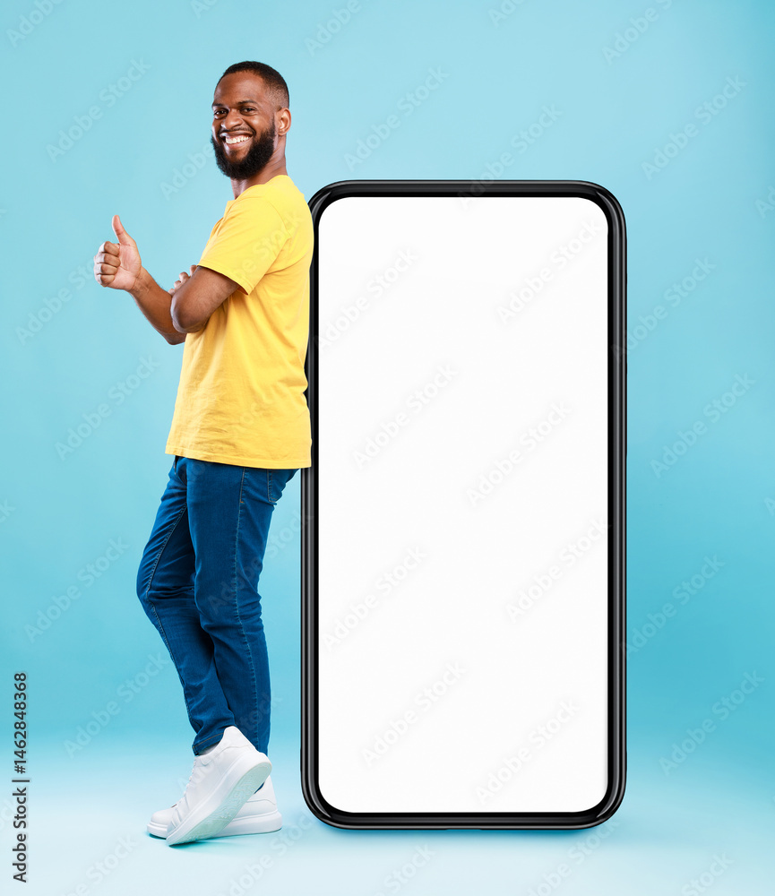 Poster funky black guy leaning on giant cellphone, showing thumb up gesture, recommending new mobile app or