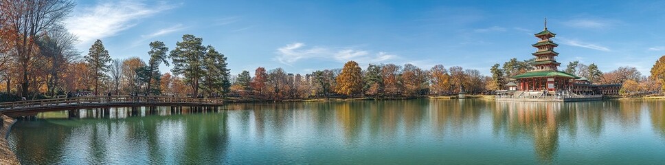 Obraz premium The scenic autumn landscape of Nara public park includes a serene pond, vibrant maple leaves, and an old oriental pavilion reflected in the water's surface
