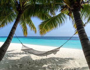 A Maldivian hammock tied between two palms, swaying gently above soft sandy shores.