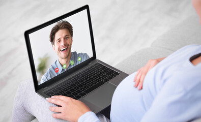 Communication Concept. Back view of pregnant girl making video call on laptop at home, chatting with excited husband