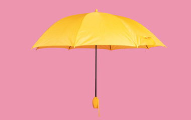 Opened yellow umbrella isolated on pastel pink studio background
