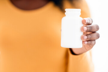 Closeup of black pregnant woman holding jar with pills or vitamins. Unrecognizable african american...