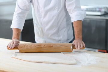 Baker man kneading dough and bakery ingredients. Bakery concept