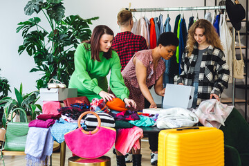 Obraz premium Home swap party. Young people, generation z exchanging clothes, branded clothing, accessories. Bargain hunting, pre-owned goods, thrift store, second hand. Sustainable eco friendly consumerism