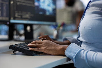 Engineer in data center typing on keyboard, optimizing IT infrastructure using network management...