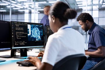 Server farm IT specialist doing AI research next to coworker, implementing algorithms using neural...