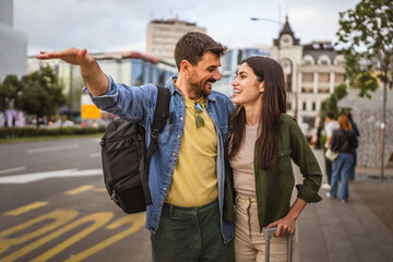 Obraz premium adult couple tourist passengers hailing a taxi on the city street