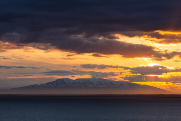 A vibrant sunset casts its colors over Cook Inlet in Anchorage, Alaska.