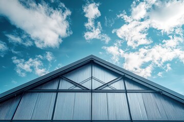 Fototapeta premium Modern industrial building's angular roof against a vibrant sky.