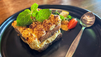 Close‑up of a layered tiramisu topped with cocoa powder