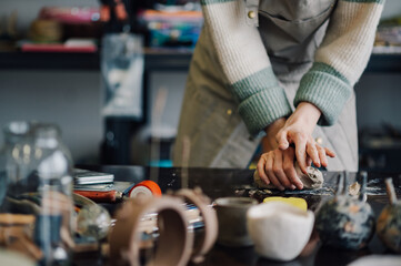 Ceramist kneading clay in pottery workshop