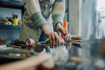 Ceramist kneading clay in pottery workshop