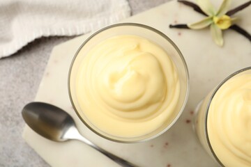 Tasty vanilla pudding, pods and flower on grey table, flat lay