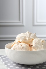 Delicious homemade meringue cookies in bowl on table
