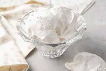 Delicious homemade meringue cookies in bowl on gray table, closeup