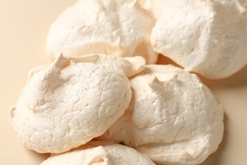 Delicious homemade meringue cookies on beige background, closeup