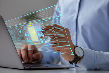 Man approving documents on virtual screen above laptop at table, closeup