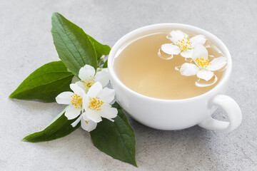 Light Green Tea with jasmine in a ceramic cup. Light gray background. Close up