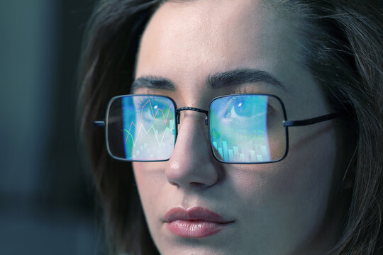 Stock exchange. Trader analyzing data, closeup. Graphs reflecting in her eyeglasses