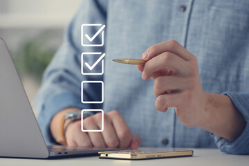 Approved. Man using laptop and checking boxes on virtual screen at table, closeup