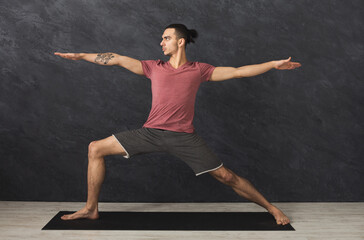 Man stretching hands and legs on mat at gym. Athlete do workout. Sport, yoga, pilates, fitness,...