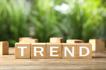 Word Trend made of wooden cubes with letters on table outdoors