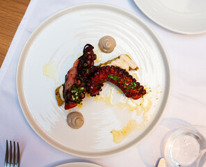 Traditional Mediterranean dish is Octopus sprinkled with greenery on top. Served with sauce