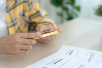woman use phone to scan barcode or QR codes to pay credit card bill after receiving document invoice online. payment, receive, paying electricity, digital payments, technology, scanning